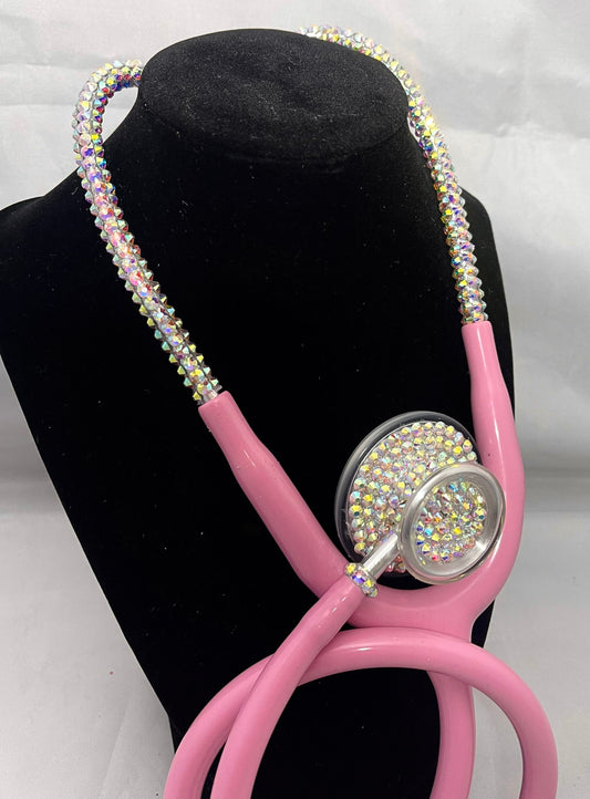 Self-Love Bling Stethoscope
This unique, handmade stethoscope features high-quality, sparkly golden iridescent rhinestones that exhibit luminous colors when viewed from various angles. Each rhinestone is individually hand-placed on a pastel pink MDF Acoustica stethoscope, ensuring both aesthetic appeal and exceptional craftsmanship.